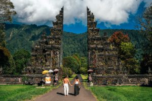 Beautiful couple at the Bali temple. Man and woman traveling in Indonesia. Couple at the Bali gate